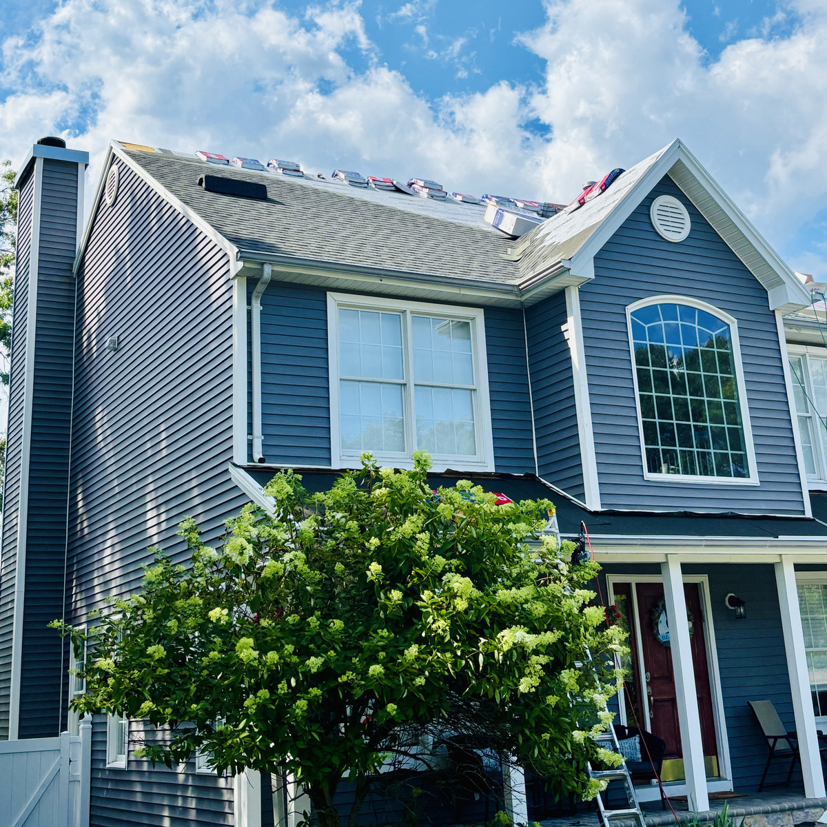 Shingle bundles staged along the ridge on a shore home